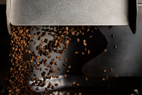 Roasted coffee cascading from La Prima Espresso Company roaster